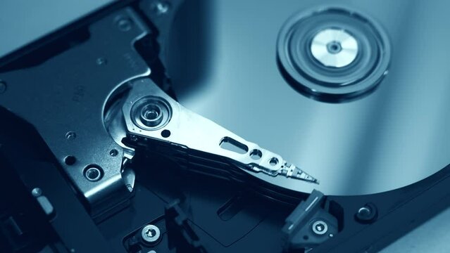 close-up view of working, opened hard disk drive. Blue color tones