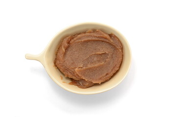 Smeared chestnut puree in a bowl isolated on white. Marrons cream, marron spread, castanea jam, homemade chestnuts dessert puddle, stain, drops, spread or splatter on white background