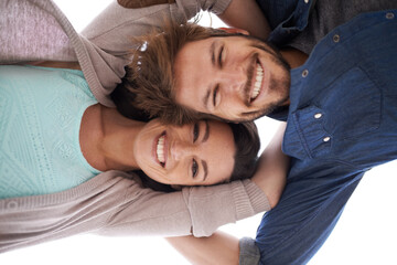 Holding onto love. a happy young couple standing close together - directly below.