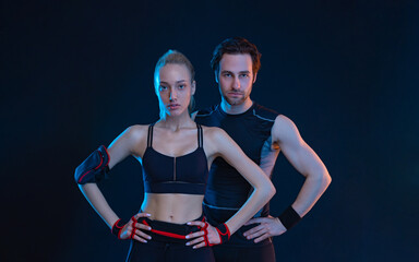 Fit couple at the gym isolated on black background. Fitness concept. Healthy life style. Sports wallpaper for sports advertising. Picture for a sports article in a magazine, website.