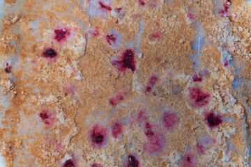 Abstract background. Cake crumbles and cherry prints left after cake on paper. Top view. Various colorful patterns on flat surface. Top view, flat lay, soft selective focus