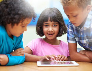 Connected in the classroom. elementary school children using a digital tablet while sitting in class.