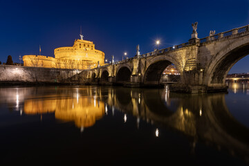 Fototapeta na wymiar Bridge and castle Sant Angelo and Tiber river at night with city lights in Rome,Italy