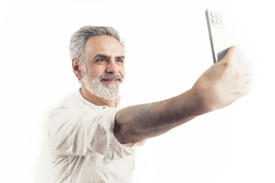 Middle-Aged Caucasian man taking a selfie using his smart phone. Isolated against white background. High quality photo