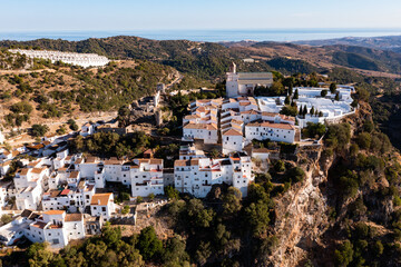 Bird's eye view of Spanish town Casares. Landscape of buildings on cliff with tiled roofs.