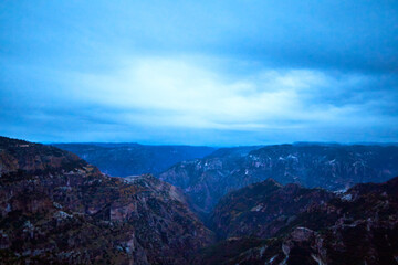 Fototapeta na wymiar blue hour in canyon with cloudy sky, blue mountains, copper canyon in sierra tarahumara, chihuahua