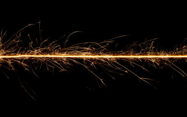 Sparkler trail of light with sparks in a straight line