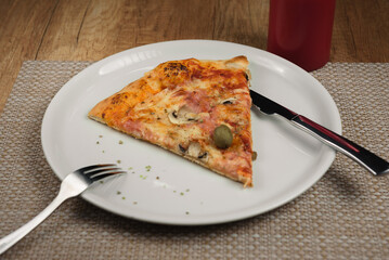 slice of pizza with ham and cheese on plate