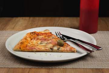 slice of pizza with ham and cheese on plate