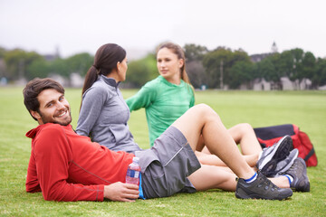 Its more fun than exercise. a group of young people relaxing on the grass after exercising.