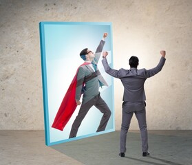 Businessman seeing himself in mirror as superhero