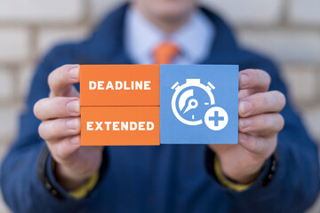 Businessman holding colorful blocks with stopwatch icon and inscription: DEADLINE EXTENDED. Lack of time. Deadline extended business work concept.