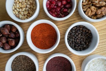 set of spices on wooden background, pomegranate, pine nut, walnut, hazelnut
