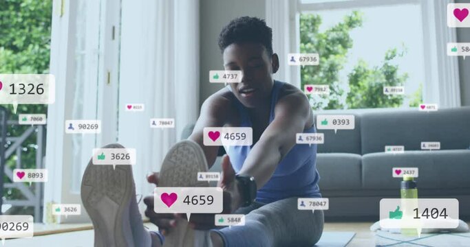 Animation of social media icons and numbers over african american woman exercising at home