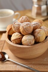 Bowl of delicious nut shaped cookies on wooden table