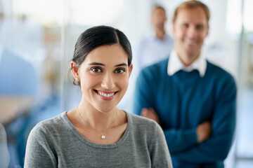 With great colleagues behind you success is inevitable. Portrait of a beautiful businesswoman standing in front of her colleagues in an office.