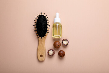 Delicious organic Macadamia nuts, cosmetic oil and brush on beige background, flat lay