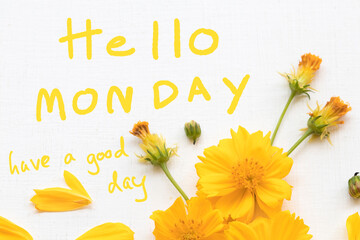 hello monday have a good day message card handwriting with yellow flower cosmos arrangement hearts flat lay postcard style on background white © phenphayom