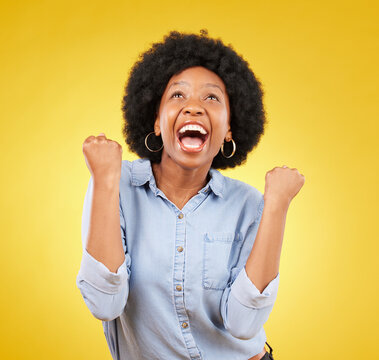 Black woman, excited face and celebrate win in studio while happy on yellow background. African female model with hands or fist for victory, promotion or bonus lottery prize achievement or surprise