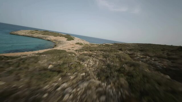 FPV drone timelapse shot of steep cliffs along the seaside with sailboats docked in Cala Varques, Mallorca, Spain during evening time.