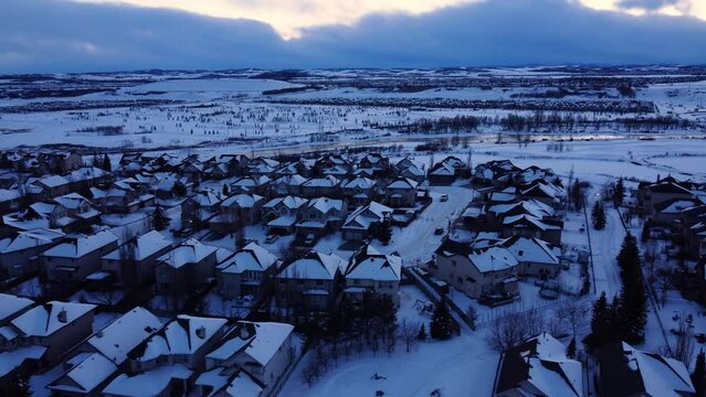 Discover the magic of winter from above as the drone glides over a quiet, snow-filled community at dusk