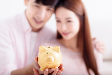 Happy  Couple holding Piggybank and Making Savings For Future