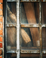 old brooms displayed on a  window 
