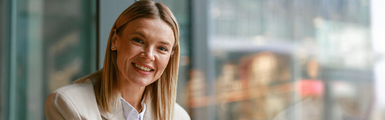 Smiling businesswoman having lunch and making notes while working in cafe