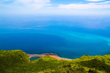 Fototapeta na wymiar Guishan Island is a beautiful scenery which Tourists call it “Turtle” with a tail and shell above the sea level. The sea is with blue gradient with the sky also named 