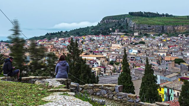 A beautiful young woman at a scenic overlook of Corleone, Sicily Italy - time lapse