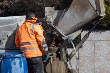 Installation for the delivery of semi-dry cement mortar for screed floors. Feeder pours sand into the mixing tank. Anlage zur Lieferung von halbtrockenem Zementmörtel für Estrichböden.