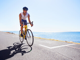 Enjoying the scenery while exercising. Cropped view of a cyclist cycling along an ocean road.