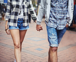 Romantic stroll. Cropped image of a couple strolling hand in hand down a paved street.