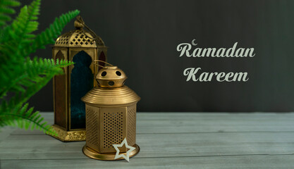 Golden lantern lamp with a plant near it, Ramadan kareem concept 2023 selective focus
