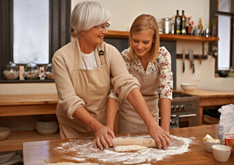 Obraz na płótnie Canvas Learning grandmas secret recipes. A grandmother teaching her granddaughter how to bake.