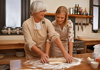 Learning grandmas secret recipes. A grandmother teaching her granddaughter how to bake.
