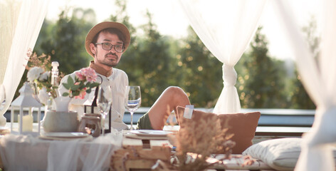 lifestyle man sitting and wait romantic dinner outdoor resort 