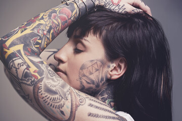 Intricate body art. A cropped studio portrait of a tattooed young woman.
