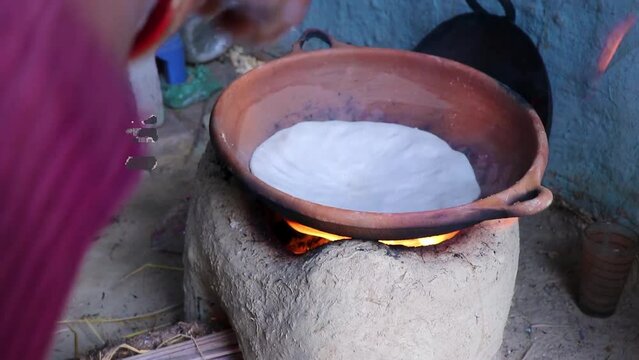 rice floor bread making in traditional soil vessels at wood fire from different angle