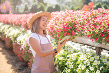 Modern technology in gardening business. confident female is wearing apron while working. portrait of female environmentalist using digital tablet in farm. Gardening business, Small business owner.