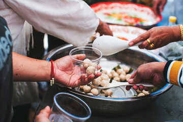 Volunteer to serve free food for the poor in a food donation center : charity concept