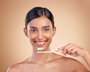 Portrait, toothbrush and toothpaste with a model woman in studio on a beige background for dental or oral hygiene. Face, mouth and dentist with an attractive young female cleaning or brushing teeth - obrazy, fototapety, plakaty
