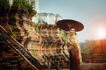 asian woman holding bamboo umbrella standing at old temple of ayutthaya world heritage site of unesco central of thailand - 581653786