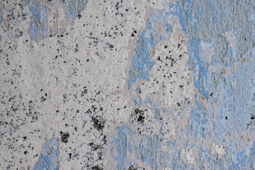 Vintage wall texture. The weathered, rough surface of a plastered concrete wall with faded, peeling paint. Perfect for background and design. Closeup. High resolution.