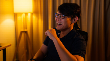Fototapeta premium watching movie at home. Asian man watching movie in computer. Leisure