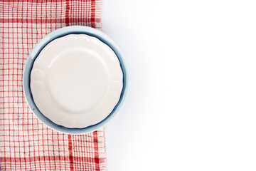 A red and white checkered tablecloth with a blue plate on top of it. isolated on white background