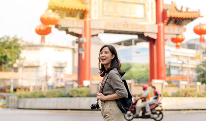 Naklejka premium Young Asian woman backpack traveler enjoying China town street food market in Bangkok, Thailand. Traveler checking out side streets.