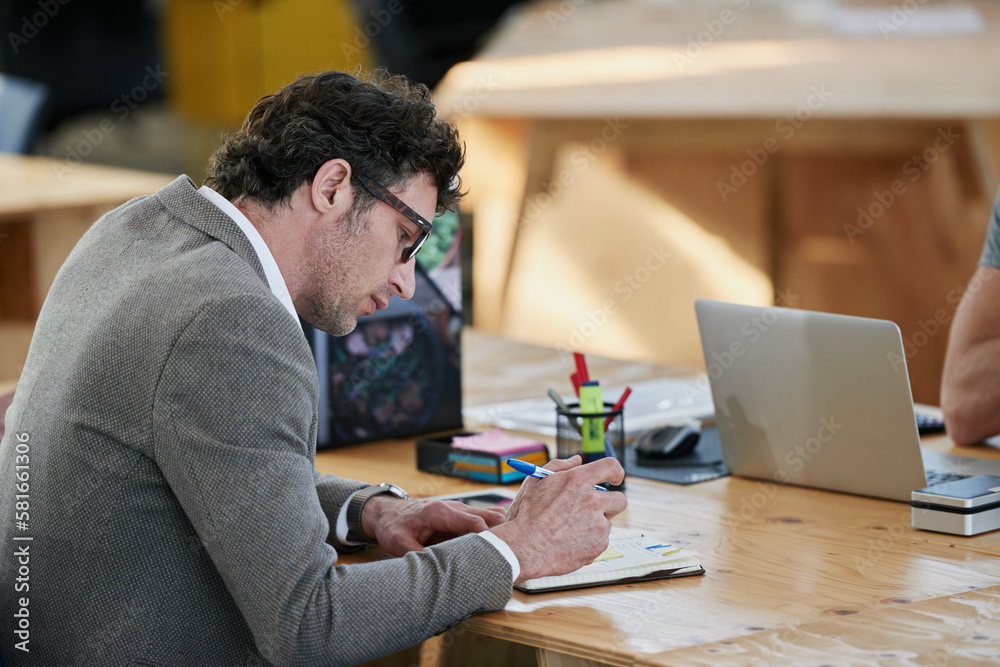 Poster deep in thought. a man working at his desk in an office.