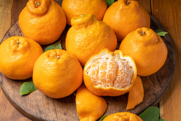 Fresh Orange fruit on Wooden table, Dekopon orange or sumo mandarin tangerine on wooden background.