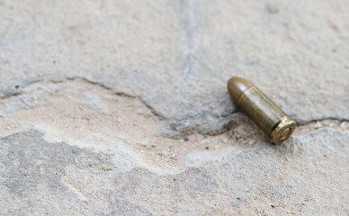Fototapeta na wymiar 9mm bullet on ground.Finding crime evidence concept.